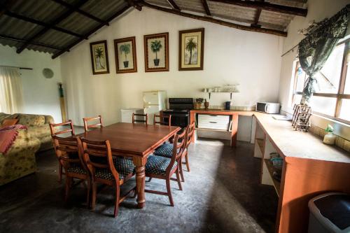 a kitchen and dining room with a wooden table and chairs at Kaia Homestead in Sodwana Bay