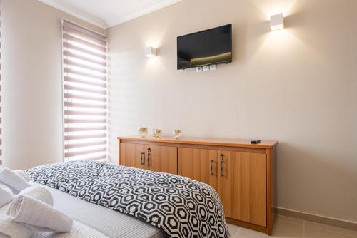 a bedroom with a bed and a television on the wall at Veria Panorama Luxury Suite With Garden. in Veria