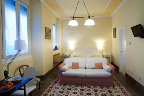 een woonkamer met een bank en een bed bij Casa Palacio López Daza in Granada