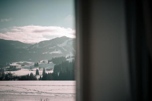 a view of a snowy mountain from a window at Mittelburg Wellnesshotel in Oy-Mittelberg