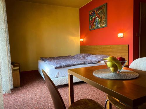 ein Schlafzimmer mit einem Bett und einem Tisch mit einer Obstschale darauf in der Unterkunft Apartmán Mountain View - Tatragolf C in Veľká Lomnica