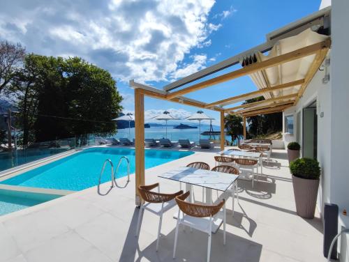 a patio with a table and chairs next to a swimming pool at Alboro seaside suites in Parga