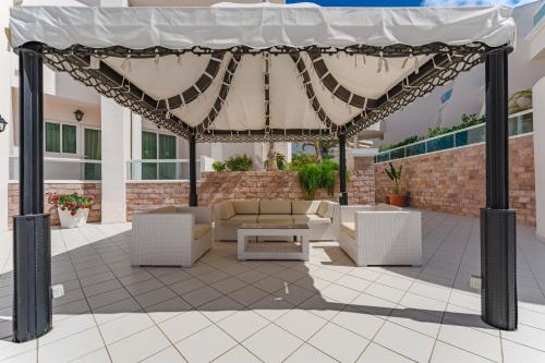 a patio area with chairs, a table, and an umbrella at Flamingo Suites Boutique Hotel in Adeje