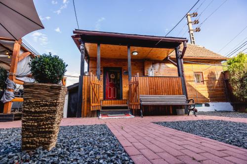 a wooden house with a red door and a porch at Cabanele Sașilor in Cisnadioara
