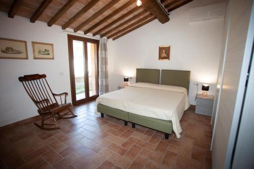 ein Schlafzimmer mit einem Bett und einem Stuhl in einem Zimmer in der Unterkunft Agriturismo San Gregorio in Chiusi