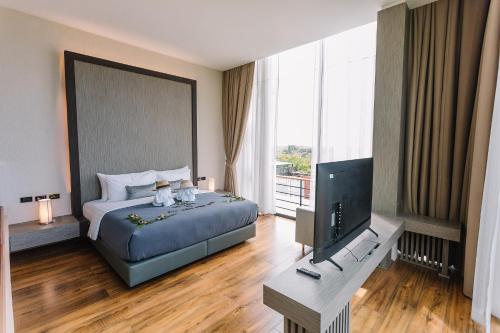 1 dormitorio con 1 cama y TV de pantalla plana en Sky View Luxury Pool Villa - SHA en Surat Thani