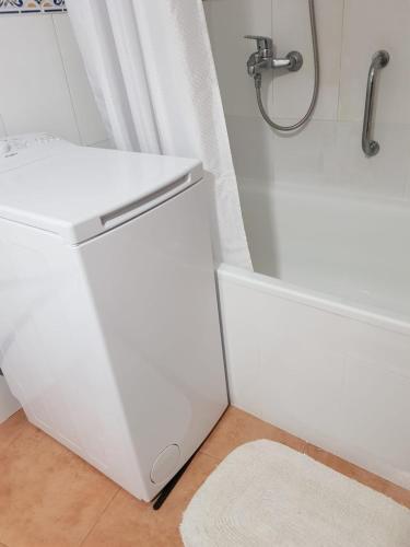 a white bathroom with a tub and a sink at Modern, cozy studio in Fuengirola