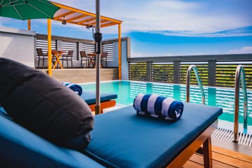 a blue bench on a balcony with a swimming pool at Maa Thundi in Fuvahmulah