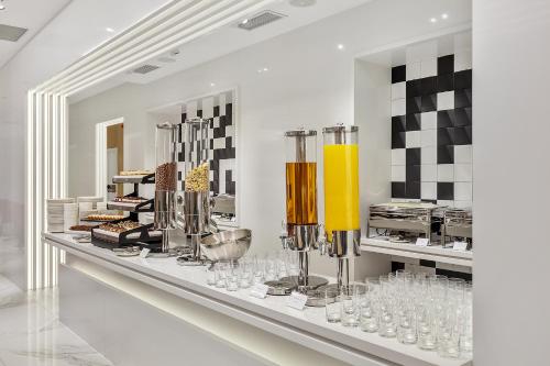 a display case in a restaurant with glasses on a counter at Clocks Hotel Tbilisi in Tbilisi City