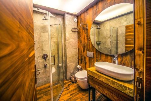 a bathroom with a sink and a toilet and a mirror at Inanlar Premium Suites & Villas in Uzungöl
