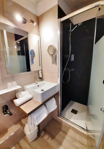 a bathroom with a sink and a shower at LOGIS Hotel Majestic Chatelaillon Plage - La Rochelle in Châtelaillon-Plage