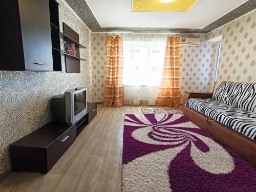 uma sala de estar com um sofá e uma televisão em Home On Gagarina em Kropyvnytskyi