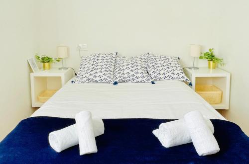 una camera da letto con un letto e due asciugamani di Apartamento Peñuelas a Siviglia
