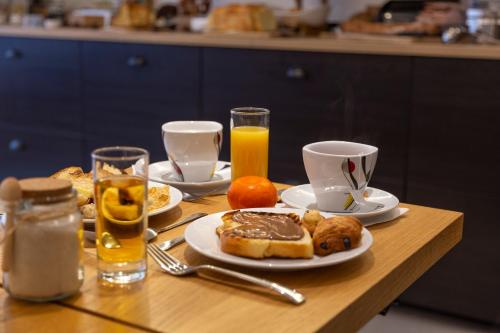 a table topped with plates of breakfast foods and drinks at Hotel Victoria in Strasbourg