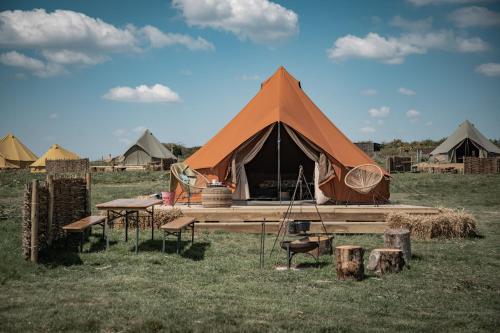a tent with a table and chairs in a field at The Sea Forts Cornwall in Torpoint