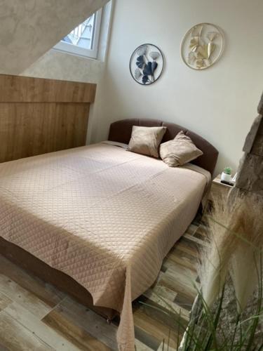 a bed in a bedroom with two plates on the wall at DivčiBor in Divčibare