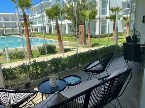 a patio with a table and chairs and a pool at Appartement vue piscine bien équipé et bien ensoleillé in Casablanca