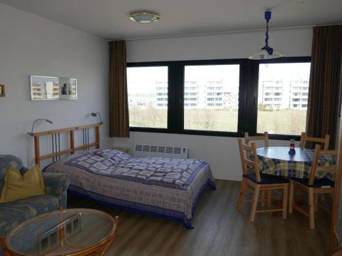een slaapkamer met een bed, een tafel en een bank bij BTSH66212-FeWo-Bootskieker in Burgtiefe auf Fehmarn 