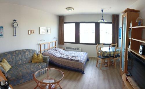een woonkamer met een bank, een bed en een tafel bij BTSH66212-FeWo-Bootskieker in Burgtiefe auf Fehmarn 
