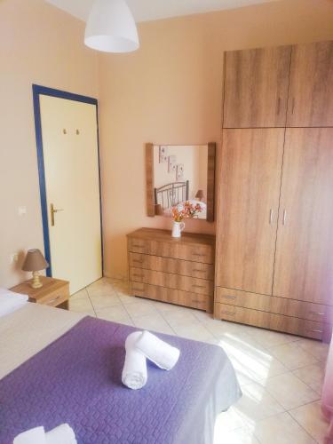 a bedroom with a purple bed and wooden cabinets at Iliada's apartment in Polychrono
