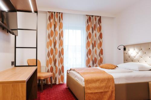 a hotel room with a large bed and a window at Hotel Der Stockinger in Premstätten