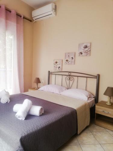 a bedroom with a bed with two towels on it at Iliada's apartment in Polychrono