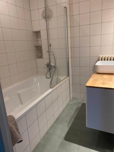 een witte badkamer met een bad en een wastafel bij Appartement d’artiste lumineux central 76m2 in Perpignan