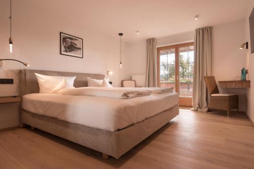 a large bedroom with a large bed and a window at Mittelburg Wellnesshotel in Oy-Mittelberg