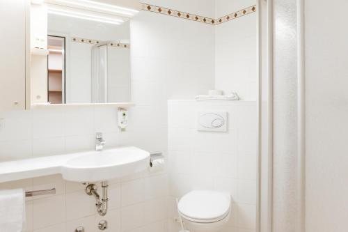 ein weißes Badezimmer mit Waschbecken und Toilette in der Unterkunft Hotel Der Stockinger in Premstätten