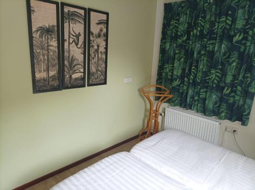 a bedroom with a bed and three pictures on the wall at Vakantie appartement de Havezate in Roden