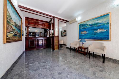 um quarto com pinturas na parede e cadeiras em Hotel Suzana Budva em Budva