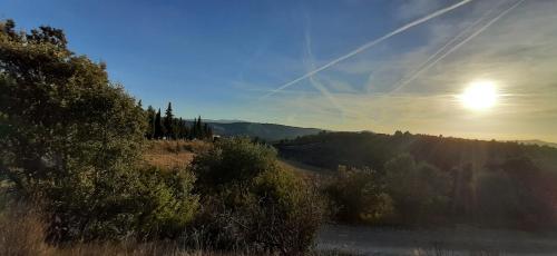 a view of a hill with the sun in the sky at Luxurious Provencal Village House, Walk to Village Pool in Rustrel