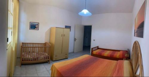 ein Schlafzimmer mit 2 Betten und einem Kinderbett in der Unterkunft Lopadusa trilo 1 in Lampedusa