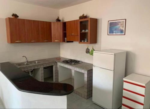 a small kitchen with a counter and a refrigerator at Lopadusa trilo 1 in Lampedusa