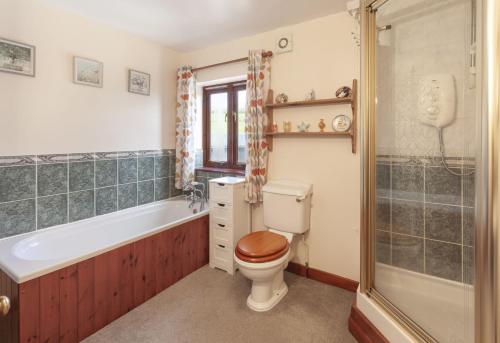 y baño con aseo, bañera y ducha. en Blagdon Cottage, Wheddon Cross, en Wheddon Cross