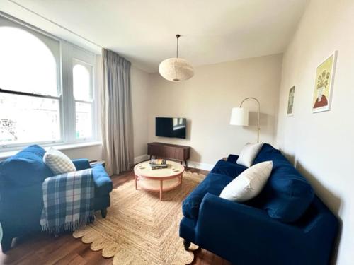 ein Wohnzimmer mit einem blauen Sofa und einem Tisch in der Unterkunft Redland Suites - Apartment 6 in Bristol