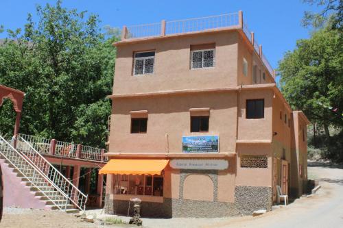 Ein altes Gebäude mit orangefarbener Markise darauf. in der Unterkunft Auberge Toubkal Amsouzart Aitst Idar in Tizgui