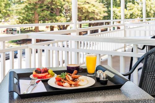 a tray with two plates of food and a drink at Esplanade Hotel Fremantle - by Rydges in Fremantle