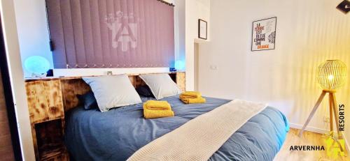 - une chambre avec un lit bleu et des oreillers jaunes dans l'établissement Gîte des Pierres Bleues, à Saint-Genès-Champanelle