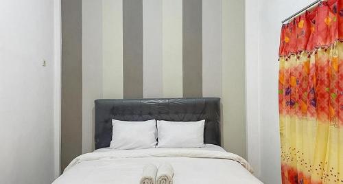 a bed with a pair of shoes on top of it at RedDoorz @ Tongas Probolinggo in Pesisir