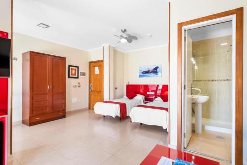 a hotel room with two beds and a sink at Hotel Andrea´s in Los Cristianos
