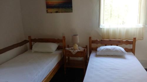 two beds sitting in a room with a window at Nature of Karapata in Koroni