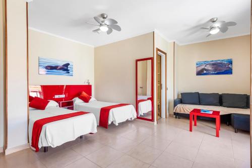 a hotel room with two beds and a couch at Hotel Andrea´s in Los Cristianos