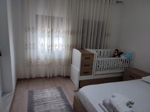 a small bedroom with a crib and a white bed at Guesthouse Belle View Old Town in Berat