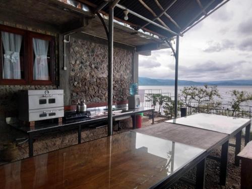 a kitchen with a table and a view of the water at Pondok Berata Dapdap in Balige