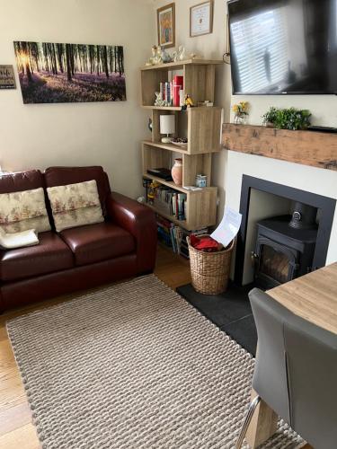 a living room with a couch and a fireplace at Lavender Cottage in Ripon
