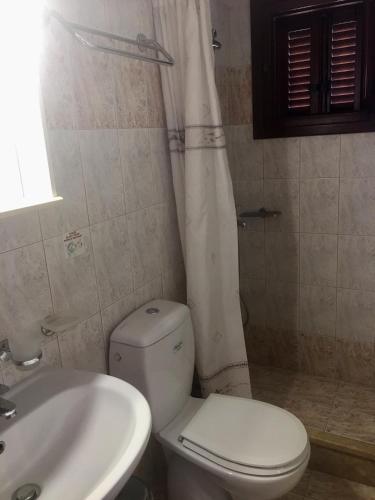 a bathroom with a white toilet and a sink at Panorama Studios in Lipsoi