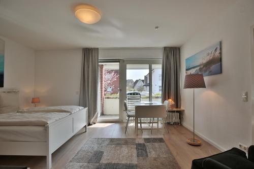 een slaapkamer met een bed en een tafel met een stoel bij Am Elchgrund Am Elchgrund 7 Appartement 2 in Timmendorfer Strand