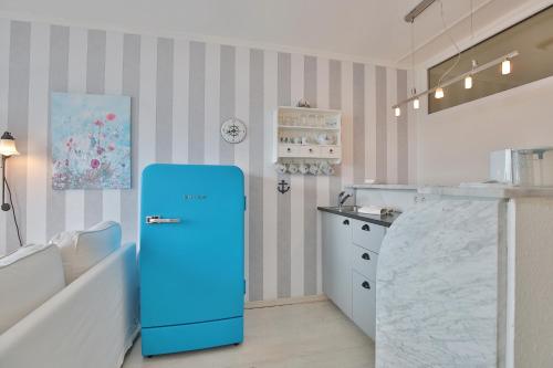 - un réfrigérateur bleu dans une cuisine à côté d'un comptoir dans l'établissement Seetempel Seetempel Appartement 38, à Scharbeutz