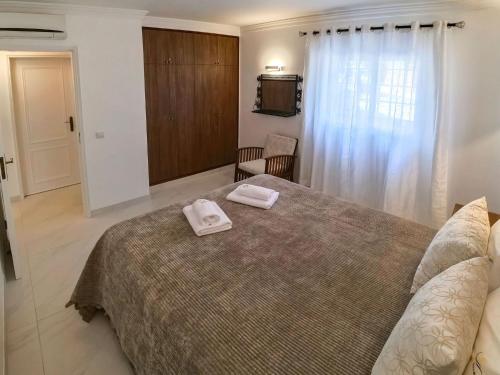 アルブフェイラにあるCasa beira mar Algarveのベッドルーム1室(ベッド1台、タオル2枚付)